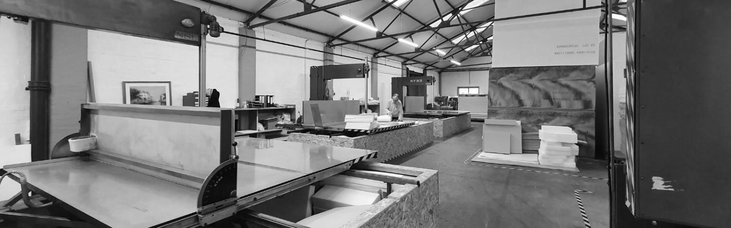Aerofoam Ltd Industrial foam cutting machine and stacked colorful foam blocks inside the factory.
